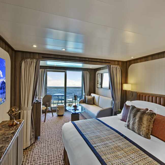 bed facing the screen with deck to outdoors in the veranda suite